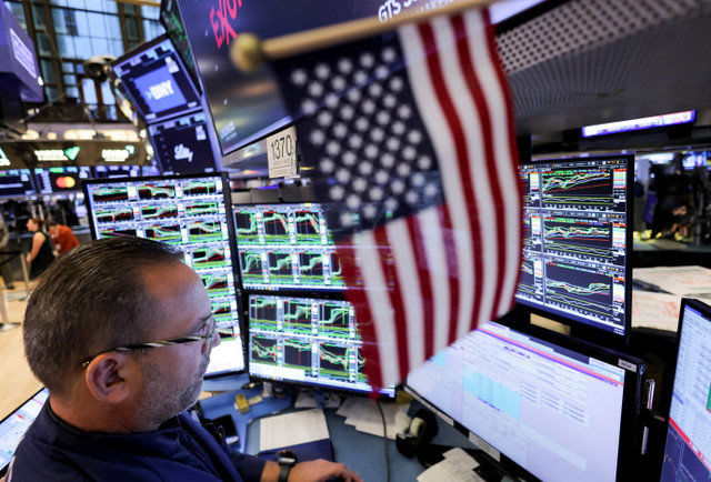 متداول يعمل في بورصة نيويورك (NYSE) بجوار علم الولايات المتحدة بعد فوز الجمهوري دونالد ترامب في الانتخابات الرئاسية الأمريكية، في مدينة نيويورك بالولايات المتحدة، 6 نوفمبر 2024. REUTERS/Andrew Kelly