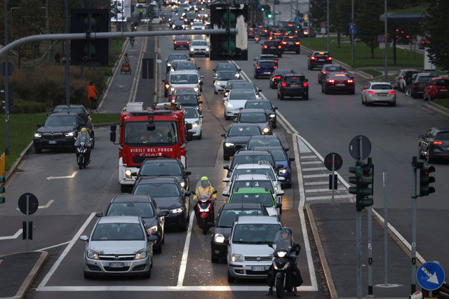 Cars are shown waiting in traffic on a road near the Porta Nuova district in Milan, Italy, on October 25, 2023. REUTERS/Claudia Greco