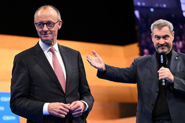 German Chancellor and leader of the Christian Democratic Union (CDU) Friedrich Merz and Bavaria's State Premier and leader of the Christian Social Union (CSU) Markus Soeder attend the CSU party convention in Munich, Germany, on December 13, 2025. REUTERS/ Angelika Warmuth