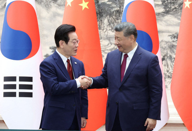 Chinese President Xi Jinping shakes hands with South Korean President Lee Jae Myung during a MOU Signing Ceremony at the Great Hall of the People in Beijing, China, January 5, 2026. Yonhap via REUTERS