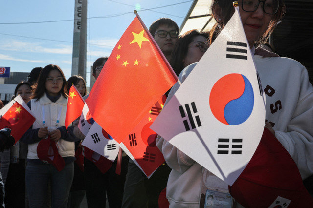 文件照片:亲中支持者在金海国际机场附近展示中国和韩国国旗,准备迎接2025年10月30日美国总统唐纳德·特朗普与中国国家主席习近平在韩国釜山亚太经济合作组织(APEC)峰会期间就贸易紧张局势和双边关系进行的会谈。REUTERS/Tyrone Siu/File Photo