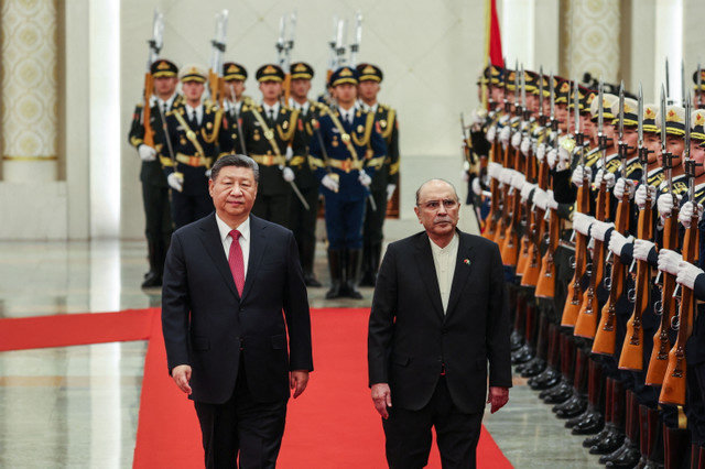 中国の習近平国家主席とパキスタンのアシフ・アリ・ザルダリ大統領が、2025年2月5日に中国北京の人民大会堂で行われた歓迎式典で儀仗兵の前を歩く。WU HAO/Pool via REUTERS