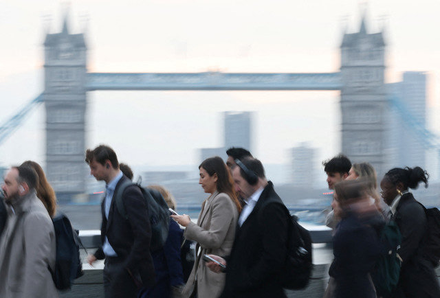 Công nhân băng qua Cầu London trong giờ cao điểm buổi sáng với Cầu Tháp phía sau, tại London, Anh, ngày 16 tháng 12 năm 2025. REUTERS/Toby Melville