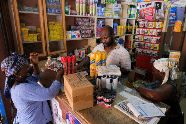 A shop owner serves customers at Makola market in Accra, Ghana, on March 26, 2022. Picture taken March 26, 2022. REUTERS/Francis Kokoroko/File Photo