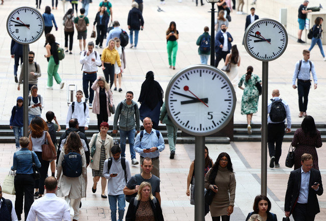 Workers walk through the Canary Wharf financial district in London, Britain, ahead of a Bank of England decision on interest rate changes, August 3, 2023. REUTERS/Toby Melville