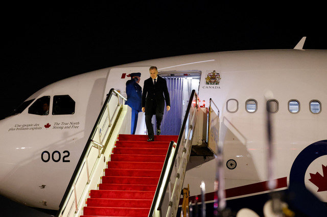 Canada's Prime Minister Mark Carney departs a plane at Beijing Capital International Airport during the first visit by a Canadian Prime Minister to China since 2017, in Beijing, China, January 14, 2026. REUTERS/Carlos Osorio