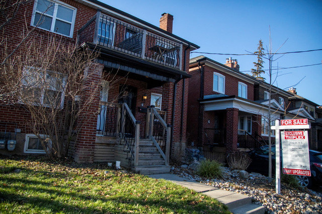 A for sale sign is displayed outside a home in Toronto, Ontario, Canada, on December 13, 2021. REUTERS/Carlos Osorio