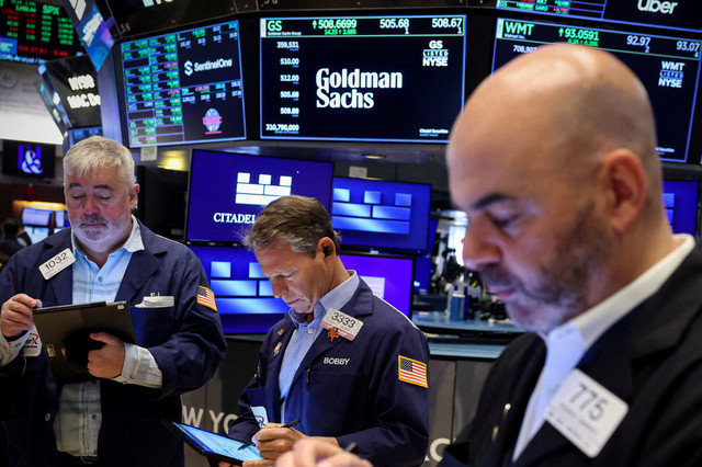 Traders work on the floor of the New York Stock Exchange (NYSE) in New York City, U.S., as a screen displays the Goldman Sachs logo and trading information on April 14, 2025. REUTERS/Brendan McDermid/File Photo