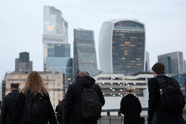 Workers cross London Bridge during the morning rush-hour with skyscrapers of the City of London financial district seen behind, in London, Britain, December 16, 2025. REUTERS/Toby Melville/File Photo