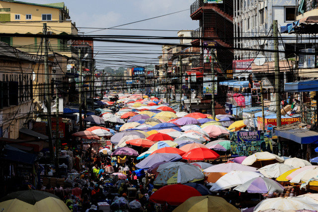 FILE PHOTO: Stall umbrellas fill sections of a busy street at Makola market in Accra, Ghana, December 6, 2025. REUTERS/Francis Kokoroko/File Photo