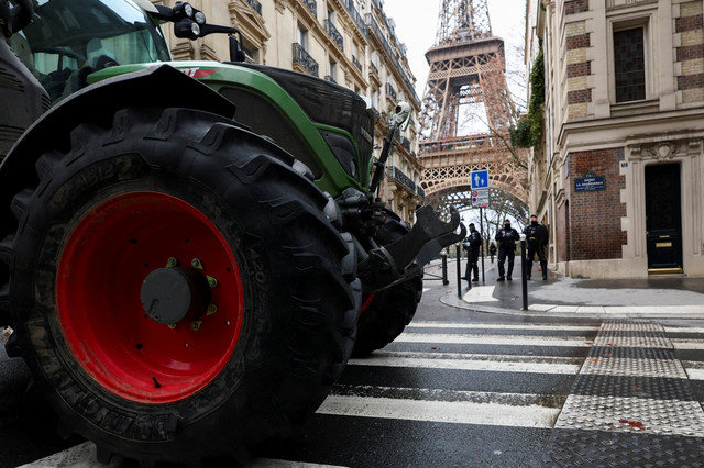 Agentes de policía permanecen junto a tractores que bloquean una carretera cerca de la Torre Eiffel, mientras agricultores franceses protestan contra la gestión del gobierno del acuerdo de libre comercio UE-Mercosur y el brote de la enfermedad de la piel rugosa, en París, Francia, el 8 de enero de 2026. REUTERS/Gonzalo Fuentes/File Photo