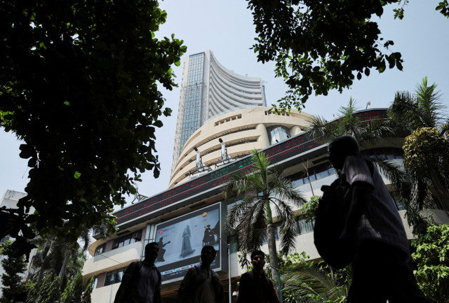 رجال يمرون بجوار شاشة تعرض نتائج السوق خارج بورصة بومباي (BSE) في مومباي، الهند، في 7 أبريل 2025. REUTERS/Francis Mascarenhas
