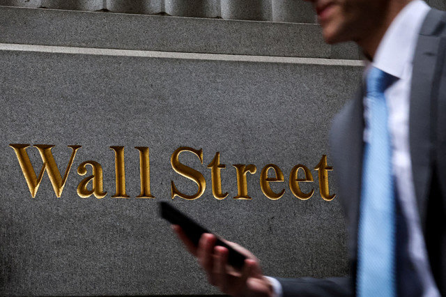 ภาพถ่ายแฟ้ม: ชายคนหนึ่งเดินบนถนนวอลสตรีทหน้าตลาดหลักทรัพย์นิวยอร์ก (NYSE) ในเมืองนิวยอร์ก สหรัฐอเมริกา วันที่ 7 เมษายน 2025 REUTERS/Brendan McDermid/File Photo
