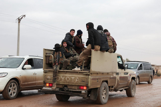 Soldados em um veículo militar em uma estrada para Dayr Hafir, a leste de Aleppo, após a retirada das Forças Democráticas Sírias (SDF) lideradas por curdos e a retomada da área pelo exército sírio em 17 de janeiro de 2026. REUTERS/Mahmoud Hassano