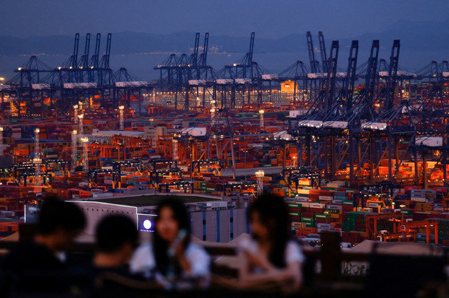 2025年5月9日、中国広東省深セン市の塩田港を見渡す丘で過ごす人々。REUTERS/Tingshu Wang