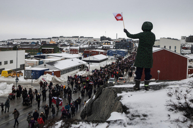 Một phụ nữ vẫy cờ Greenland khi mọi người tham gia cuộc biểu tình tại Nuuk, Greenland, vào ngày 17 tháng 1, nhằm phản đối yêu cầu của Tổng thống Hoa Kỳ Donald Trump về việc nhượng lại hòn đảo Bắc Cực này cho Hoa Kỳ và kêu gọi quyền tự quyết cho hòn đảo. REUTERS/Marko Djurica