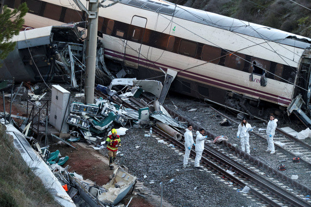 A firefighter and members of the Spanish Civil Guard work next to one of the trains involved in the accident, at the site of a deadly derailment of two high-speed trains near Adamuz, in Cordoba, Spain, January 19, 2026. REUTERS/Susana Vera