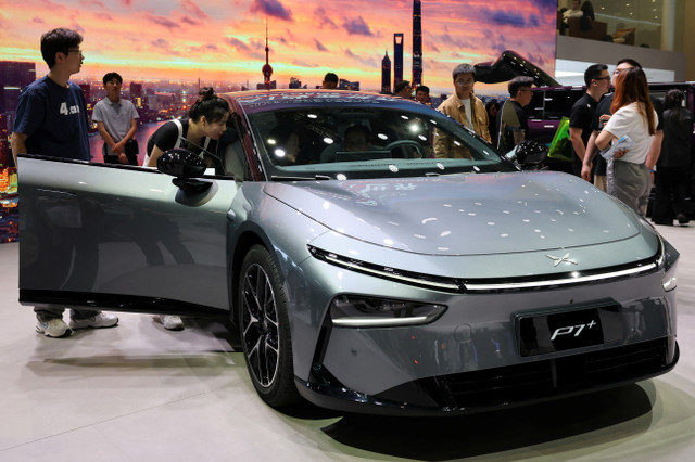 أشخاص يشاهدون سيارة XPeng P7+ الكهربائية (EV) خلال يوم إعلامي لمعرض أوتو شانغهاي في شانغهاي، الصين، 23 أبريل 2025. REUTERS/Go Nakamura
