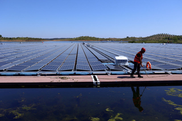 FILE PHOTO: A worker is seen during the installation of EDP's (Energias de Portugal) largest floating solar farm on a dam in Europe, on the surface of Alqueva dam, in Moura, Portugal, May 5, 2022. REUTERS/Pedro Nunes/File Photo