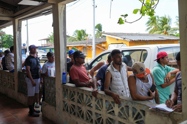 Migrantes venezuelanos inscrevem-se enquanto aguardam a única distribuição de alimentos do dia e procuram pagar um barco para a Colômbia, com esperanças renovadas de voltar para casa após a captura de Nicolás Maduro pelos EUA e perspectivas de eleições democráticas e recuperação económica, em Miramar, Panamá, 14 de janeiro de 2026. REUTERS/Enea Lebrun