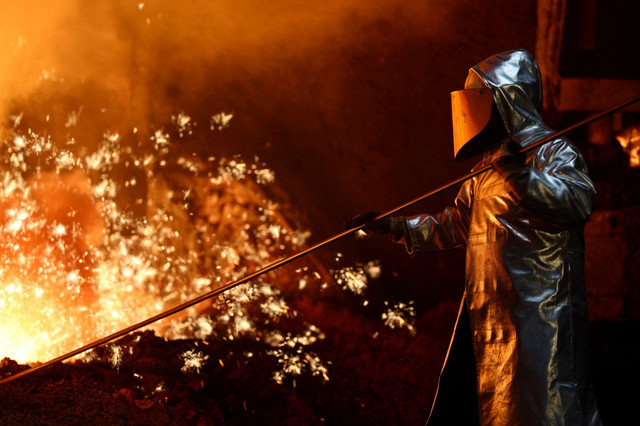 FILE PHOTO: A steel worker stands amid sparks of raw iron coming from a blast furnace at a ThyssenKrupp steel factory in Duisburg, Germany, November 5, 2025. REUTERS/Leon Kuegeler/File Photo