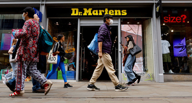 2023年5月26日、英国・マンチェスターにあるドクターマーチンの店舗前を歩く人々。REUTERS/Jason Cairnduff/File Photo