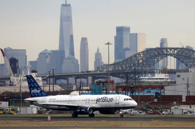 A JetBlue passenger jet lands with New York City as a backdrop, at Newark Liberty International Airport, New Jersey, U.S., December 6, 2019. REUTERS/Chris Helgren