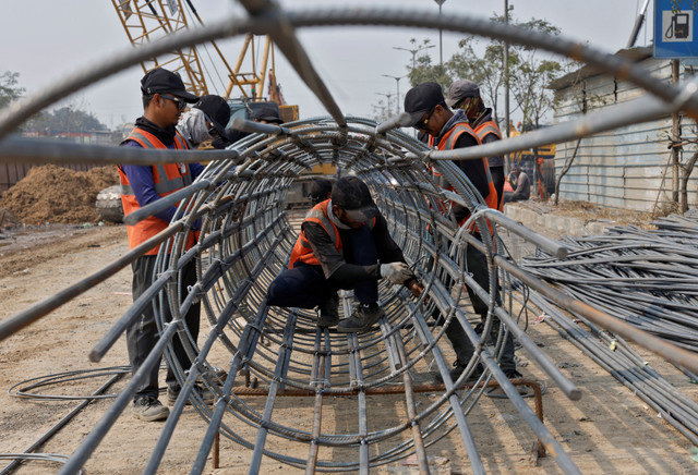 2026年1月22日、インドのアーメダバード郊外にある高架橋の建設現場で、鉄筋を固定する作業員たち。REUTERS/Amit Dave