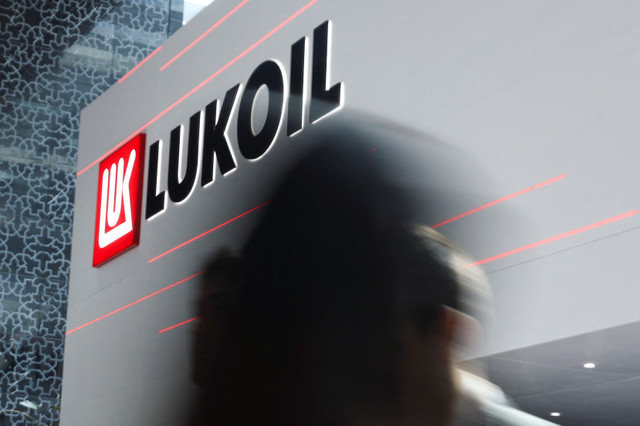 Pessoas passam por um logótipo da Lukoil durante o evento anual da indústria energética Abu Dhabi International Petroleum Exhibition and Conference (ADIPEC) em Abu Dhabi, Emirados Árabes Unidos, em 3 de novembro de 2025. REUTERS/Amr Alfiky