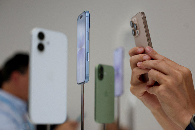 FILE PHOTO: A person uses a phone to capture iPhones on display during Apple's event at the Steve Jobs Theater in Cupertino, California, U.S. September 9, 2025. REUTERS/Manuel Orbegozo/File Photo