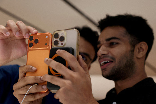 ภาพแฟ้ม: ลูกค้าเปรียบเทียบ iPhone เครื่องเก่าของเขากับ iPhone 17 pro max ที่เพิ่งเปิดตัวใหม่ที่ร้านค้าปลีก Apple ในเดลี ประเทศอินเดีย เมื่อวันที่ 19 กันยายน 2025 REUTERS/Bhawika Chhabra/File Photo