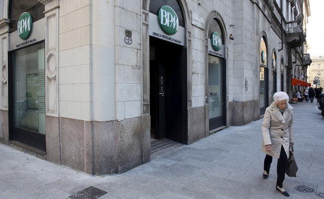 ผู้หญิงคนหนึ่งเดินผ่านธนาคาร Banca Popolare di Milano (BPM) ในย่านใจกลางเมืองมิลาน ประเทศอิตาลี เมื่อวันที่ 11 กุมภาพันธ์ 2016 REUTERS/Stefano Rellandini