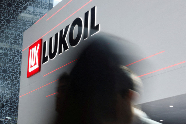 FOTO DE ARQUIVO: Pessoas passam por um logotipo da Lukoil durante o evento anual da indústria de energia Abu Dhabi International Petroleum Exhibition and Conference (ADIPEC) em Abu Dhabi, Emirados Árabes Unidos, em 3 de novembro de 2025. REUTERS/Amr Alfiky/File Photo