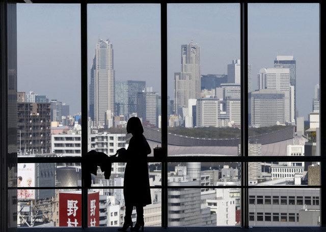 資料写真:2016年3月18日、日本の東京・新宿区にある高層ビルで、摩天楼を見渡す窓を背に女性のシルエットが浮かんでいる。REUTERS/Issei Kato/File Photo