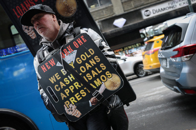 Un trabajador lleva un cartel publicitario en el distrito de los diamantes de Manhattan mientras los precios mundiales del oro se sitúan cerca de máximos históricos en Nueva York, 7 de enero de 2026. REUTERS/Mike Segar