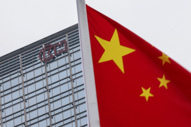 2025年4月1日、中国の香港で、長江センタービルとCKハチソンのロゴを背景に風になびく中国の国旗。REUTERS/Tyrone Siu