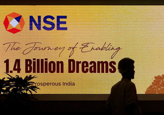 ภาพแฟ้ม: ชายคนหนึ่งเดินผ่านโลโก้ของตลาดหลักทรัพย์แห่งชาติ (NSE) ที่สำนักงานใหญ่ในเมืองมุมไบ ประเทศอินเดีย เมื่อวันที่ 17 กันยายน 2025 REUTERS/Francis Mascarenhas/File Photo