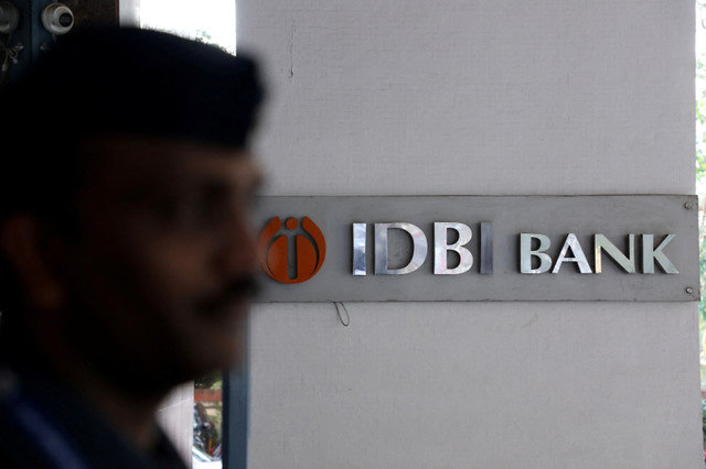 2023年4月18日、インドのムンバイにあるIDBI銀行本部の外で、ロゴの横に立つ民間警備員。REUTERS/Niharika Kulkarni