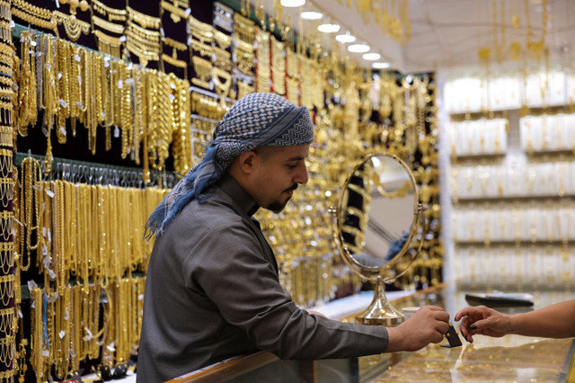 A jeweller shows a piece of gold jewellery to a customer at Dubai’s Gold Souk, in Dubai, United Arab Emirates, January 20, 2026. REUTERS/Amr Alfiky
