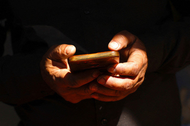 FILE PHOTO: A man uses his mobile phone in New Delhi, India, March 28, 2025. REUTERS/Priyanshu Singh/File Photo