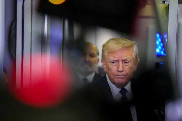 FILE PHOTO: U.S. President Donald Trump looks on as he speaks with members of the media on board Air Force One en route to Palm Beach, Florida, U.S., February 6, 2026. REUTERS/Ken Cedeno/File Photo