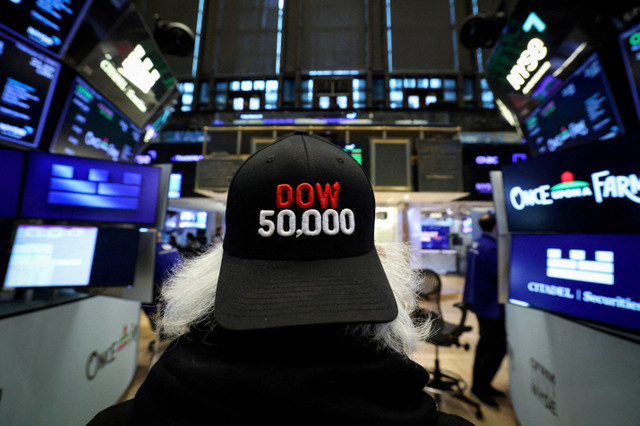資料写真:2026年2月6日、米国ニューヨーク市のニューヨーク証券取引所(NYSE)で、ダウ工業株30種平均が5万ドルの大台を突破する中、フロアで働くトレーダーたち。REUTERS/Brendan McDermid/File Photo