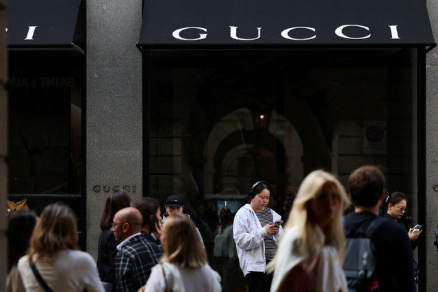 2025年9月24日、イタリアのミラノにあるグッチの店舗の前に立つ人々。REUTERS/Yara Nardi/File Photo
