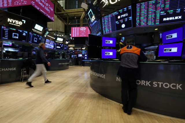 FILE PHOTO: Traders work on the floor at the New York Stock Exchange (NYSE) in New York City, U.S., January 28, 2026. REUTERS/Brendan McDermid/File Photo