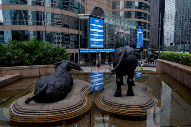 Estátuas de touros estão em frente a telas que mostram o índice de ações Hang Seng e os preços das ações do lado fora da Exchange Square em Hong Kong, China, em 18 de agosto de 2023. REUTERS/Tyrone Siu/File Photo