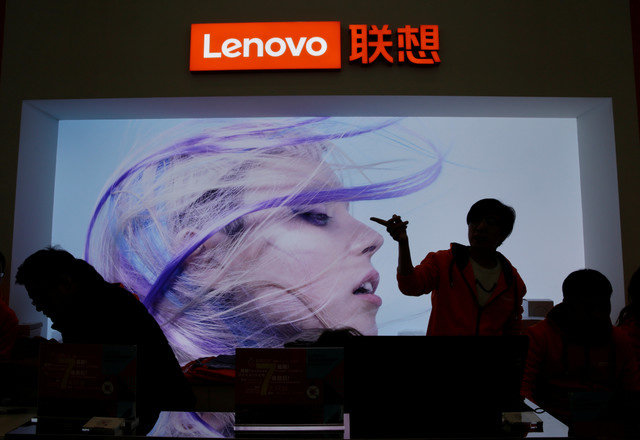An employee gestures next to a Lenovo logo at Lenovo Tech World in Beijing, China, on November 15, 2019. REUTERS/Jason Lee