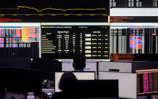 Stockbrokers trade at their terminals at the National Stock Exchange (NSE) in Mumbai, India, October 21, 2025. REUTERS/Francis Mascarenhas