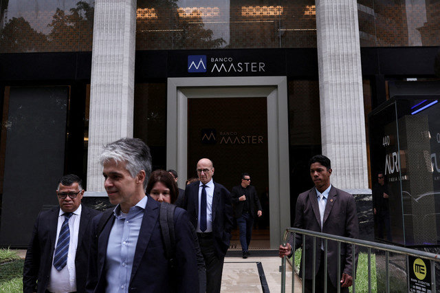 Um segurança segura uma grade enquanto pessoas deixam o Banco Master após a prisão do acionista controlador da instituição, o empresário Daniel Vorcaro, em São Paulo, Brasil, em 18 de novembro de 2025. REUTERS/ Amanda Perobelli/File Photo