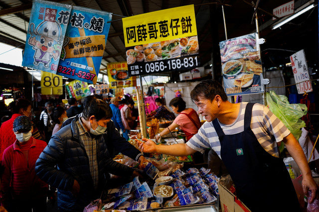 People sell products at their stall at a market in New Taipei City, Taiwan January 31, 2024. REUTERS/Ann Wang