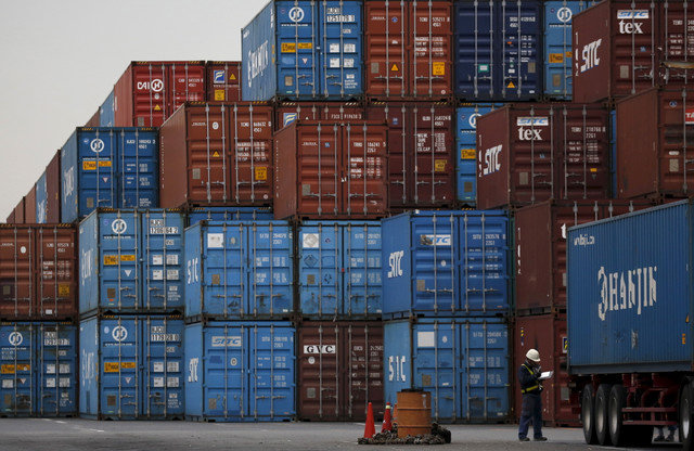 A laborer works in a container area at a port in Tokyo, Japan, March 16, 2016. REUTERS/Toru Hanai